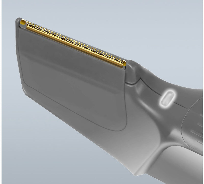 Close-up of a gray electric shaver with gold contact strip on a light blue background