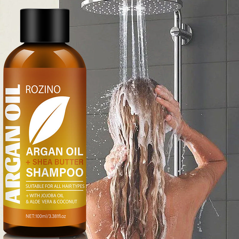 Rozino Argan Oil + Shea Butter Shampoo bottle with a person washing hair in the shower.