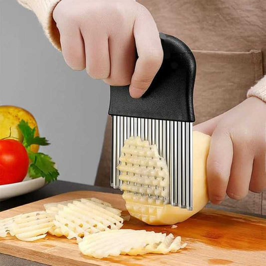 Black crinkle cutter slicer with wavy cutting blades, hand holding over potato