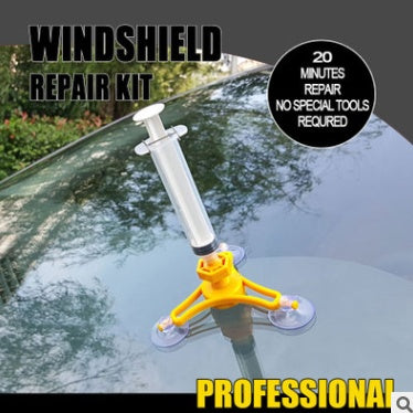 Windshield repair kit with syringe and suction cups on a car windshield.