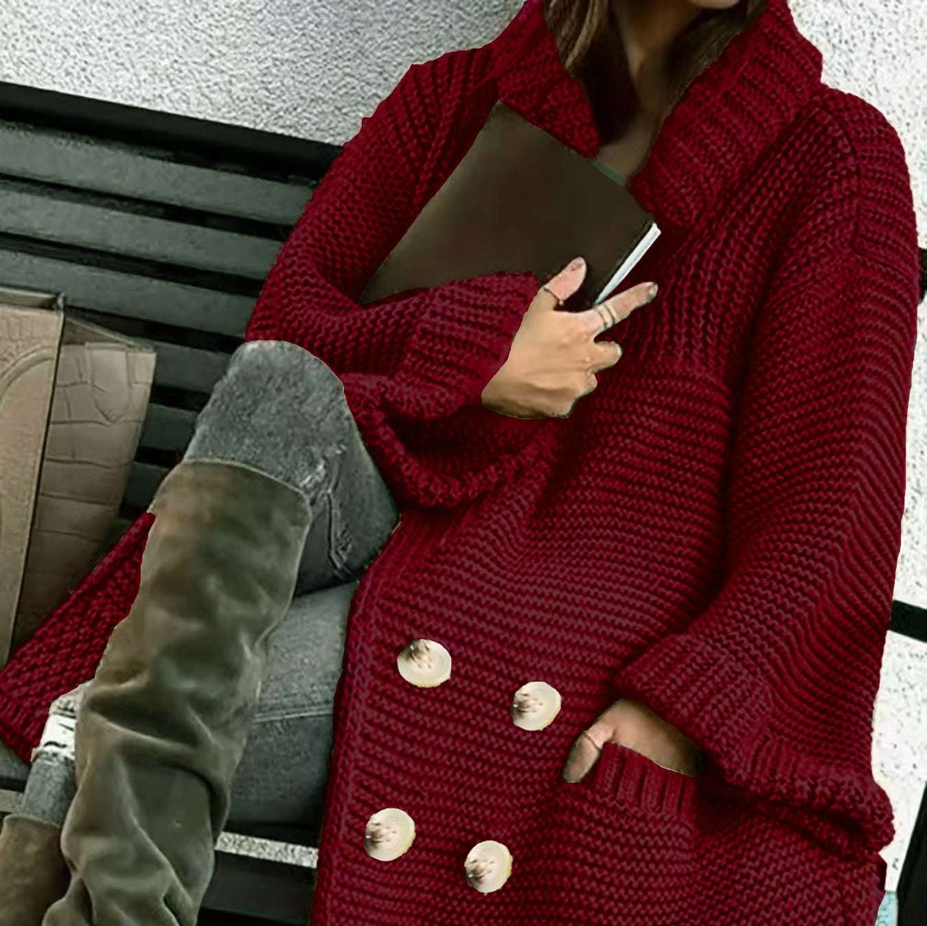 Person wearing a red knitted cardigan with gold buttons, sitting on a bench.