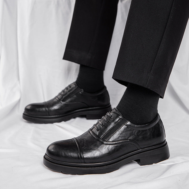 Black leather dress shoes worn with black pants on a white background