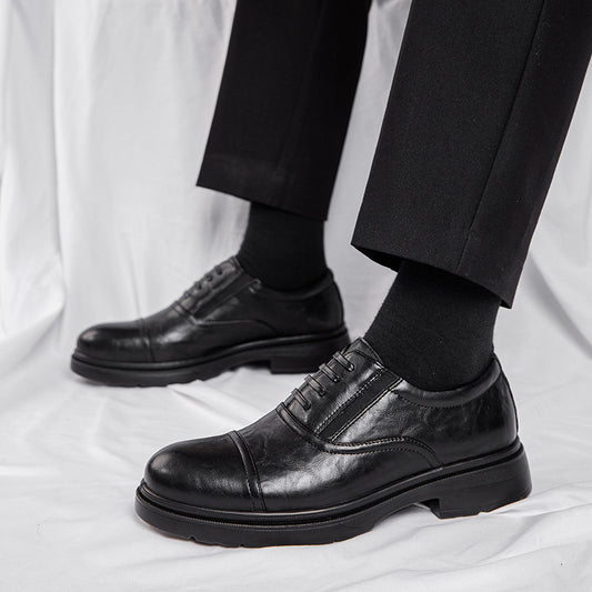 Black leather dress shoes worn with black pants on a white background