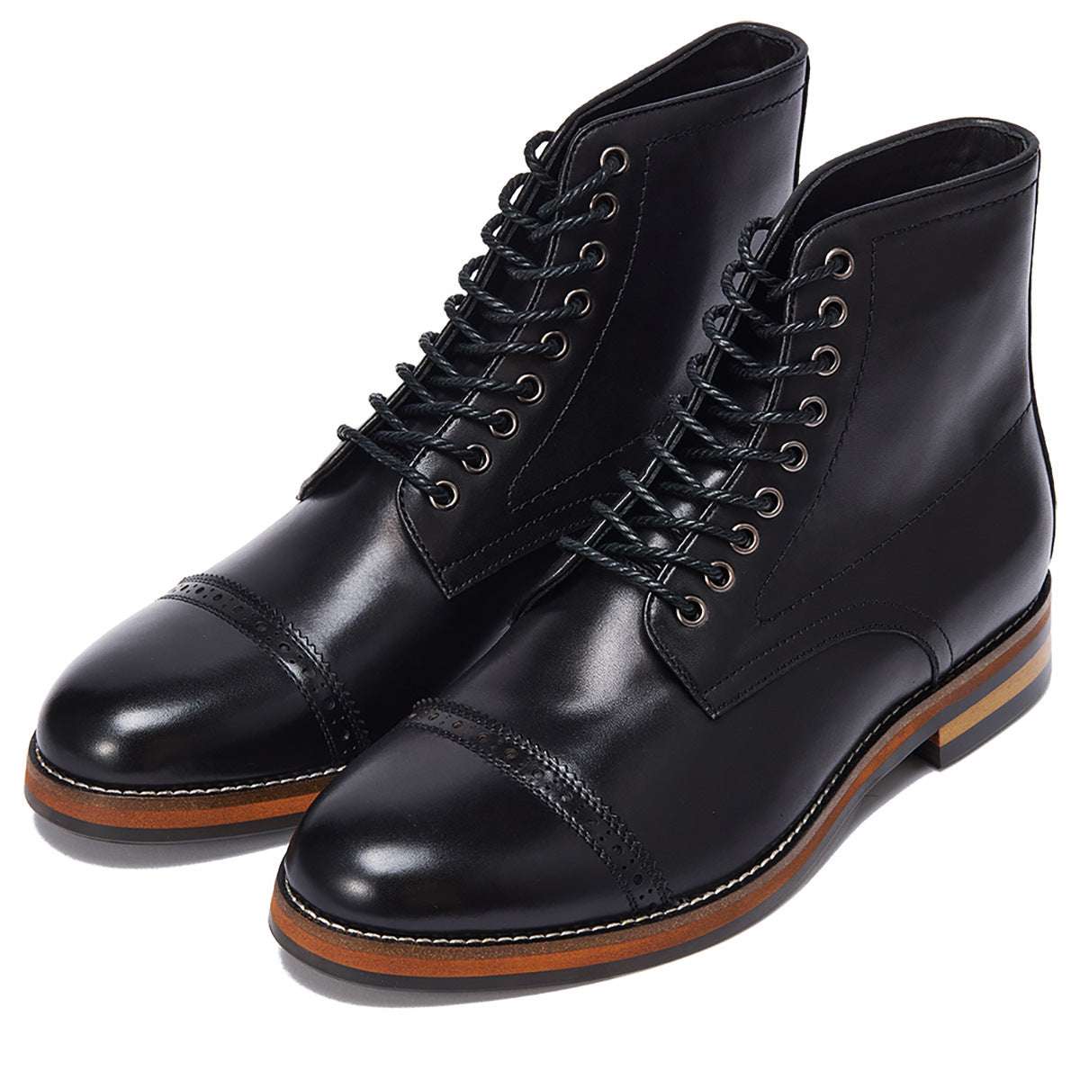 Pair of black leather boots with brown soles on a white background