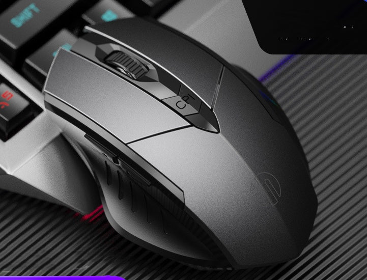 Gaming mouse on a textured surface with keyboard in the background