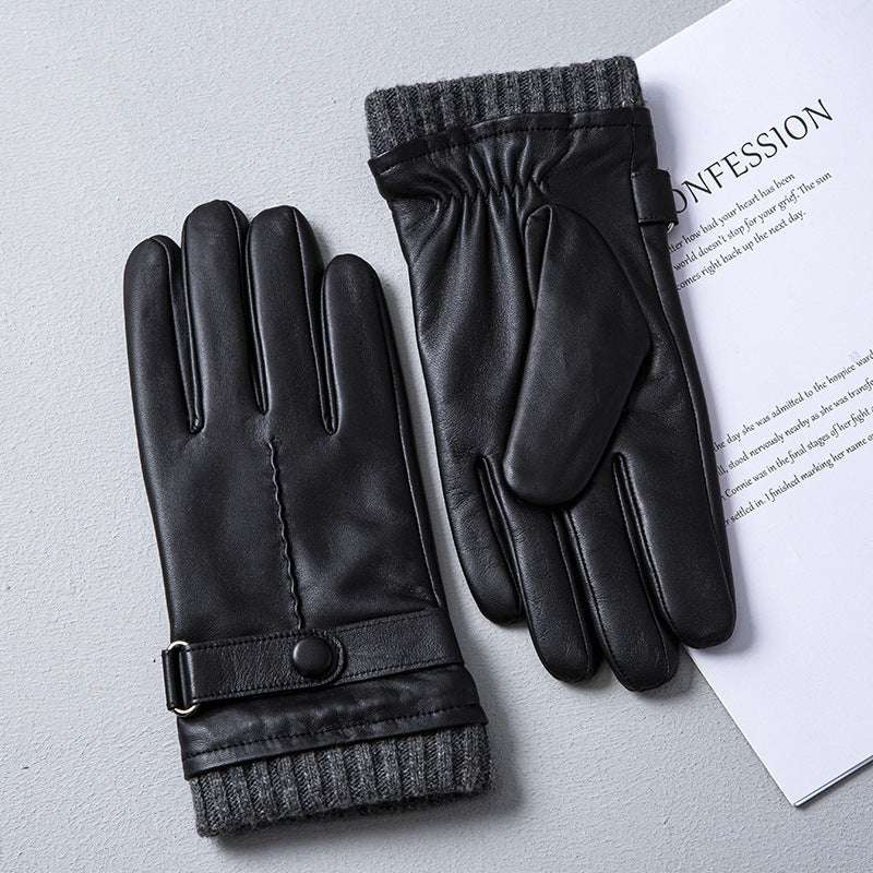 Black leather gloves with gray cuffs on a light gray surface