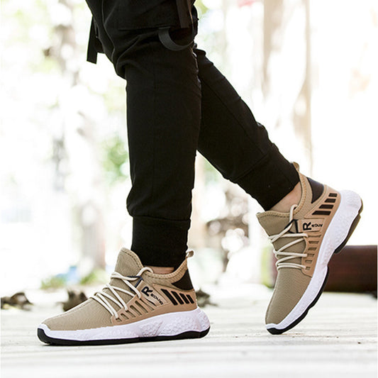 Beige sneakers with black and white accents worn by a person on a blurred outdoor background