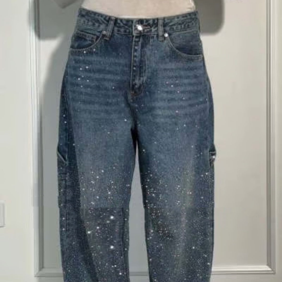 Blue jeans with glittery embellishments on a neutral background