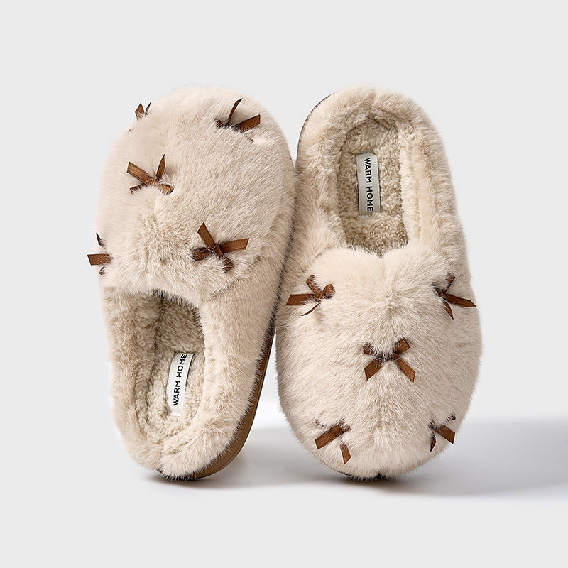 A set of women's plush home slippers with butterfly knot design. The slippers are shown in beige, white, and pink colors with a round toe and thick sole.