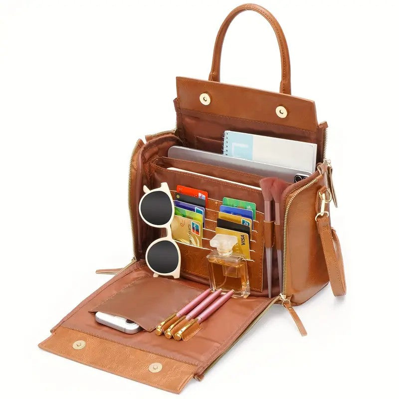 Brown leather shoulder bag open with document sleeves, phone slots, and zip pocket