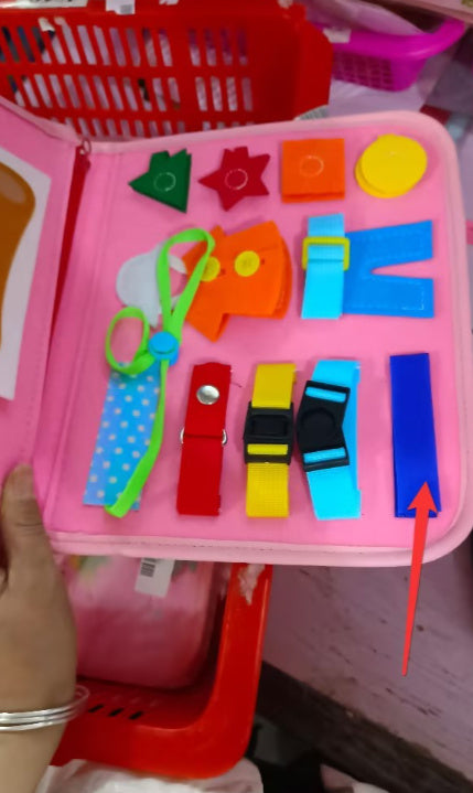 Colorful educational toys in a pink box with a hand holding it.