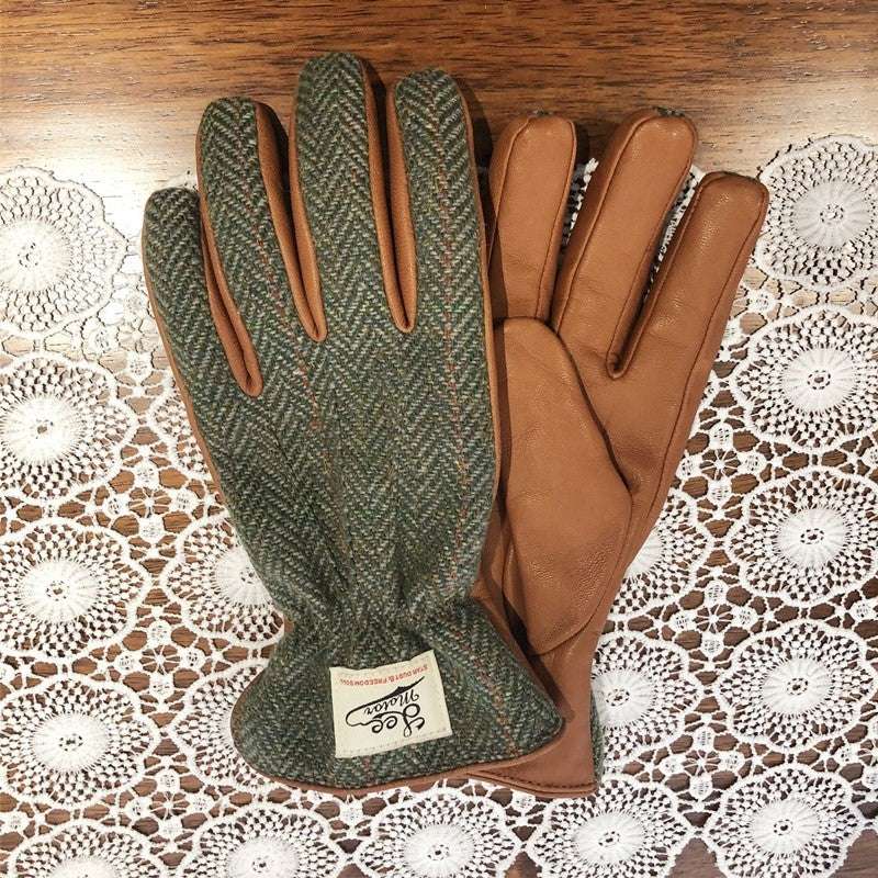 Motorcycle leather gloves: one green patterned, one tan/brown leather, stitched cuffs