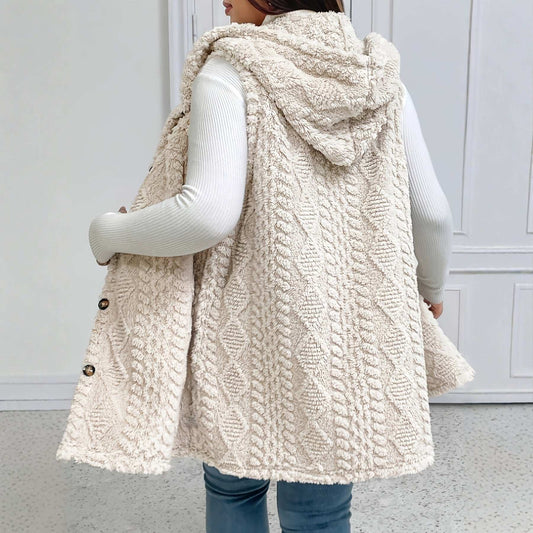 Person wearing a cream-colored knitted vest with buttons indoors.