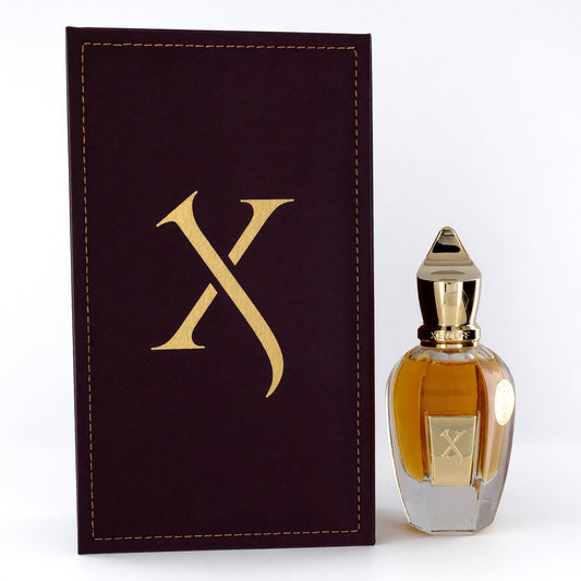 Parfum spray bottle with amber liquid, gold cap, and matching box with gold X emblem