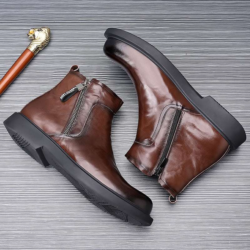 Brown leather boots with black soles on a textured gray background