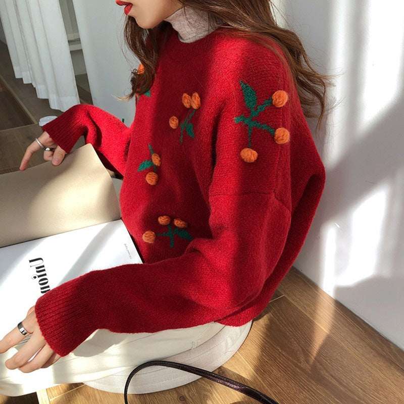 Person wearing a red sweater with decorative elements sitting on a chair.