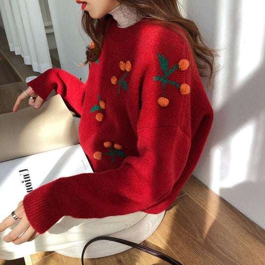 Person wearing a red sweater with decorative elements sitting on a chair.