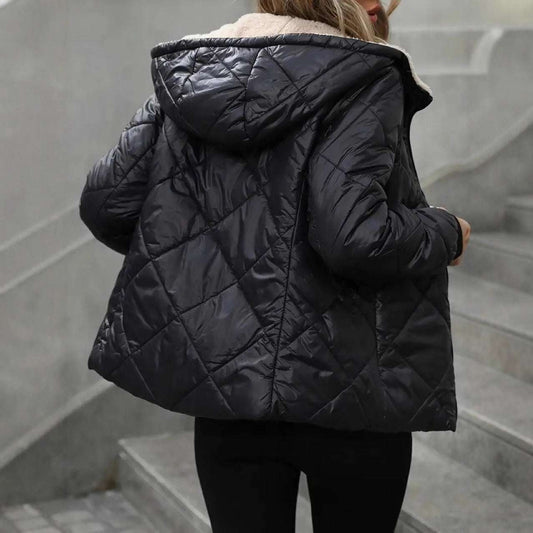 Person wearing a black quilted jacket on a staircase