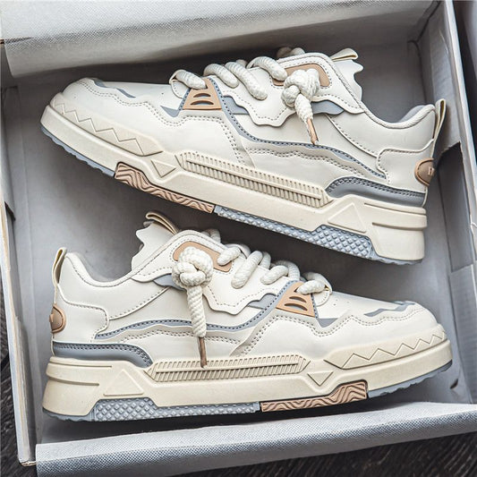 A pair of beige sports board shoes placed inside a shoebox, with the laces tied and the sole visible.