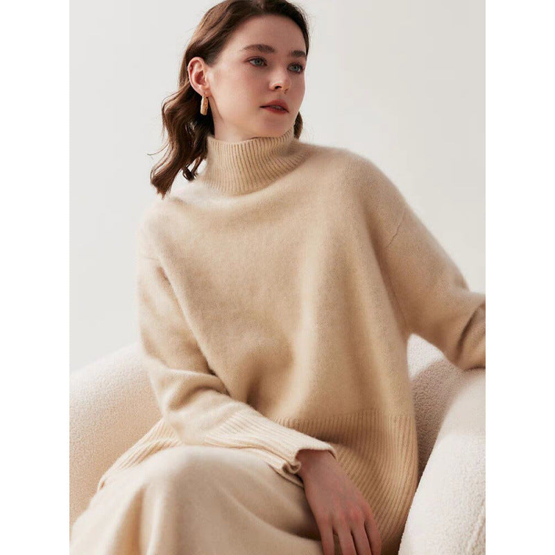 Woman wearing a beige sweater sitting on a white couch.
