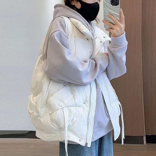 Person wearing a white puffer vest over a gray hoodie, taking a mirror selfie.