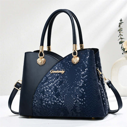 Blue stone-pattern tote bag with black handles, gold hardware, and crossbody strap