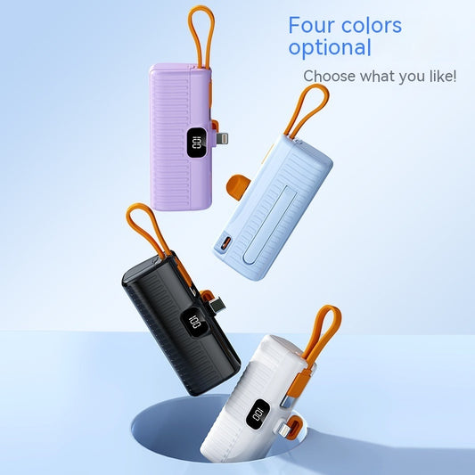 Four portable capsule-shaped power banks in different colors (black, white, purple, blue) with digital displays and attached to a keychain.