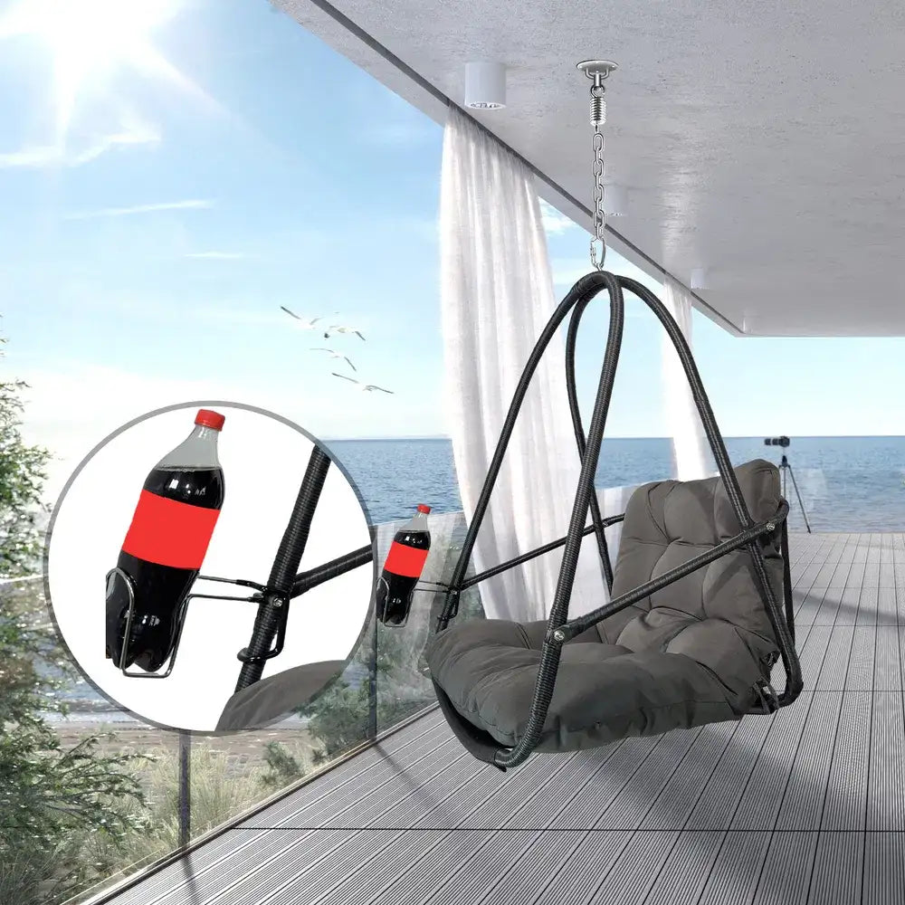 Hanging egg chair with dark woven frame and cushioned swing seat, suspended by chain.