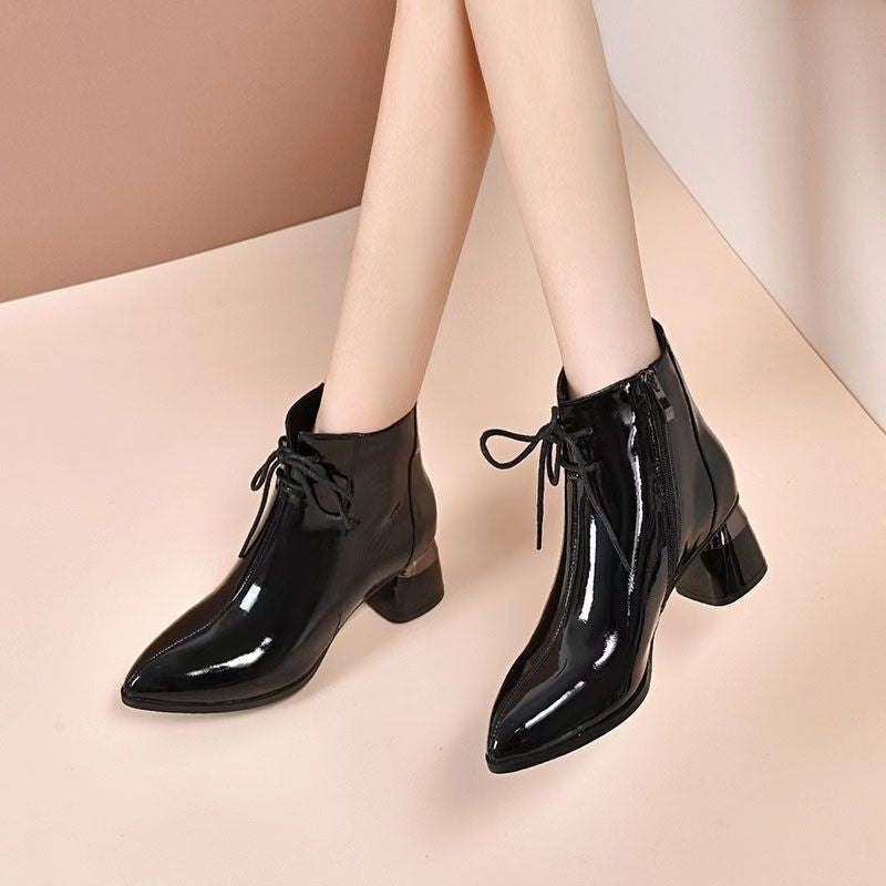 Pair of black patent lace-up mid-heel boots with pointed toe and side detailing