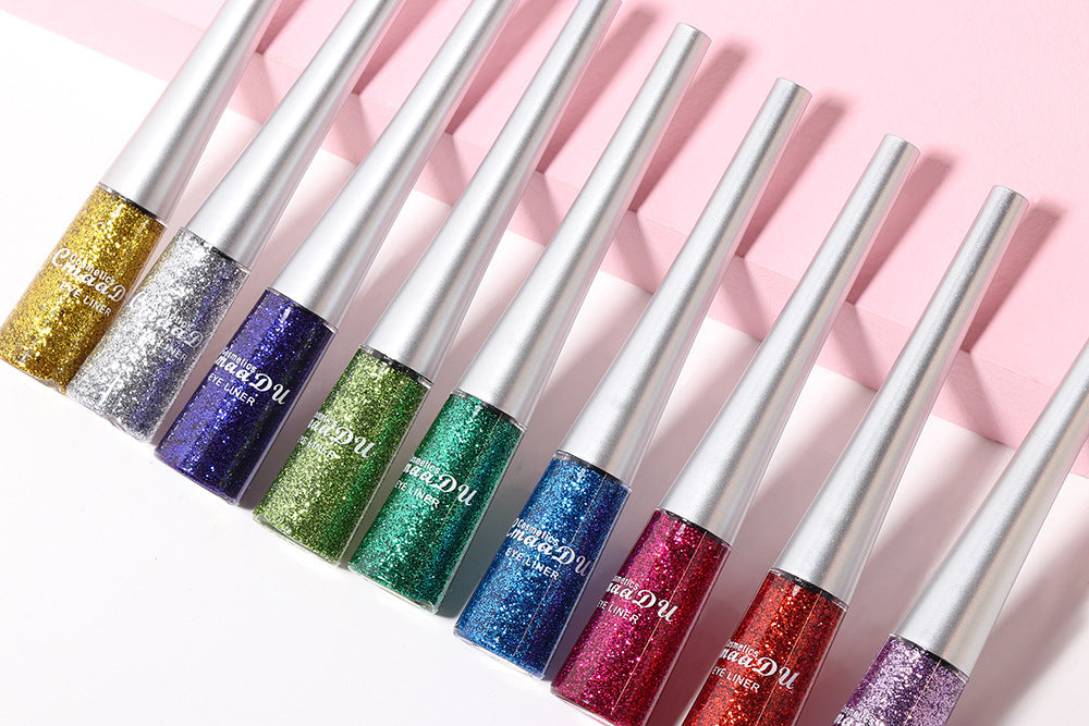 Set of colorful lip glosses with glittery finish on a pink background