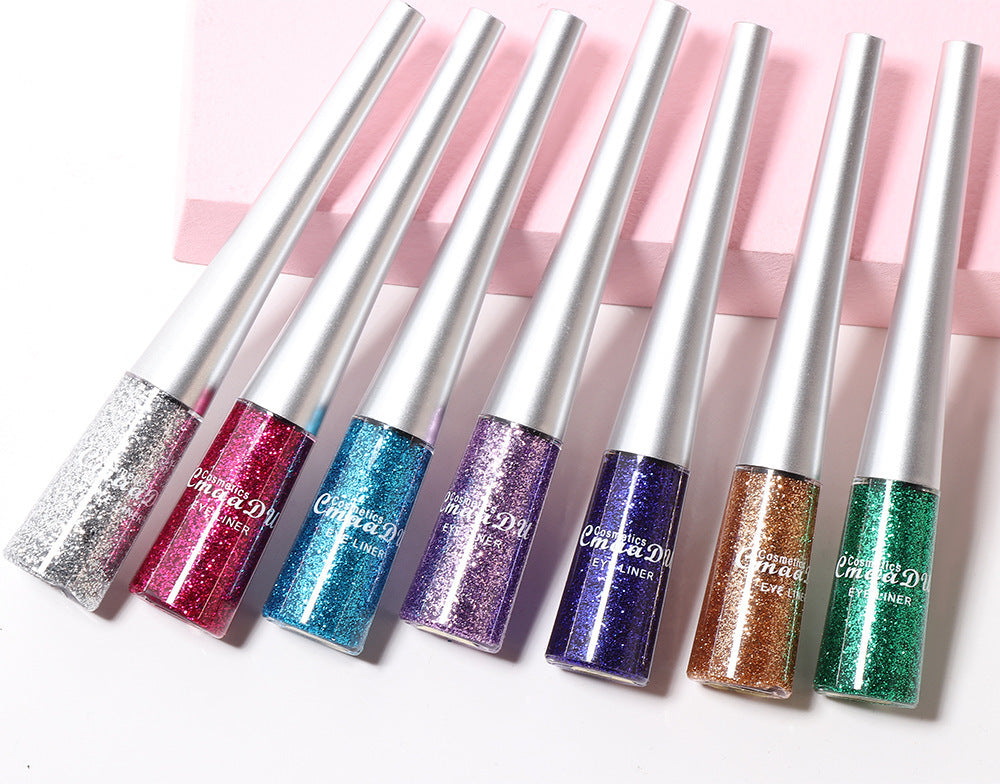 Set of glittery lip glosses with silver applicators on a white background