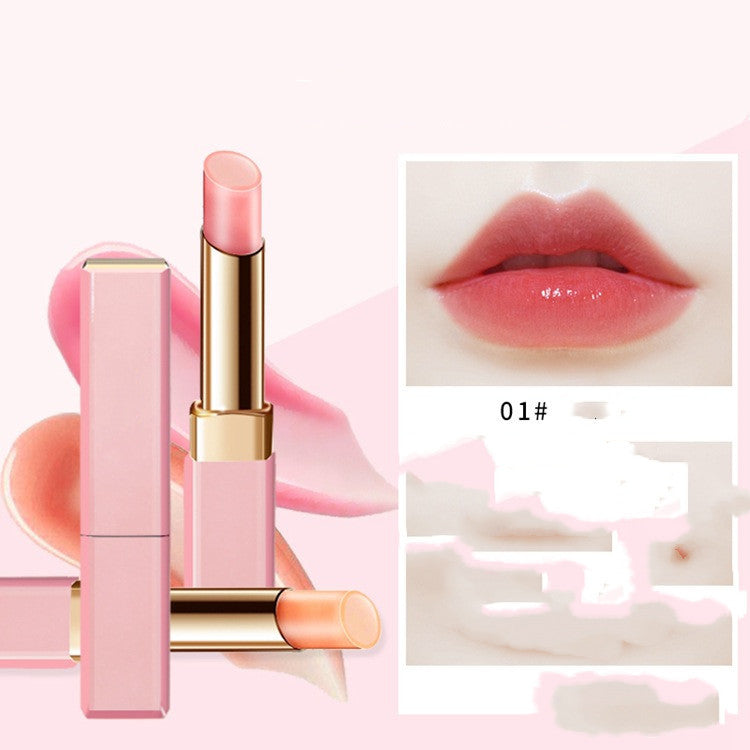 Pink lipstick with gold accents on a pink background, showing a close-up of lips wearing the shade.