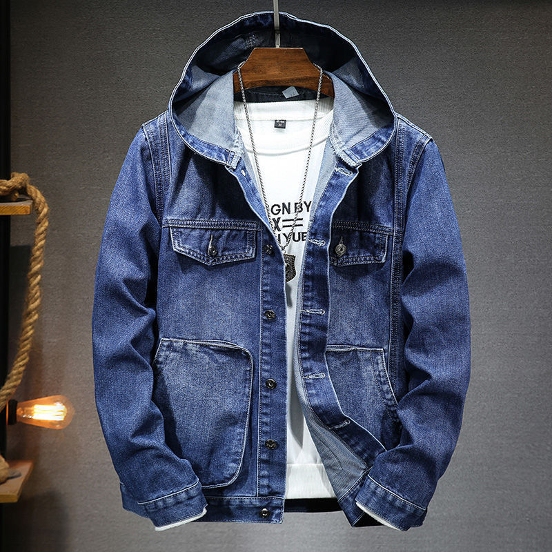 Blue denim jacket on a hanger against a gray background