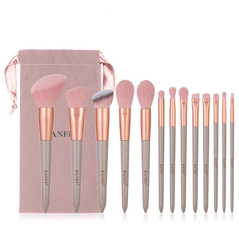 Set of makeup brushes with rose gold and gray handles, including a carrying case, on a white background.