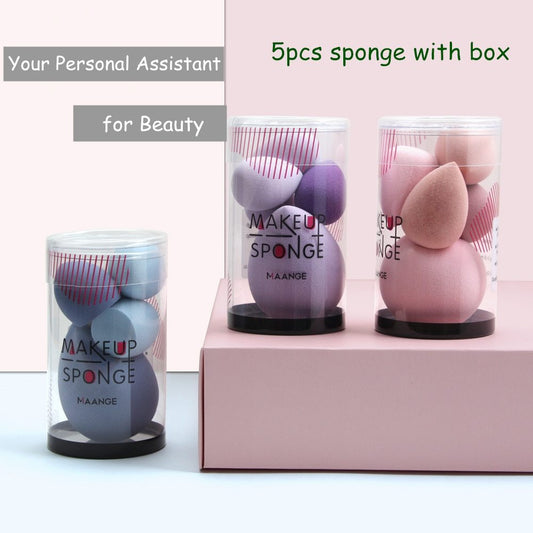 Set of makeup sponges in clear packaging with 'MAANGE' branding on a light pink background.