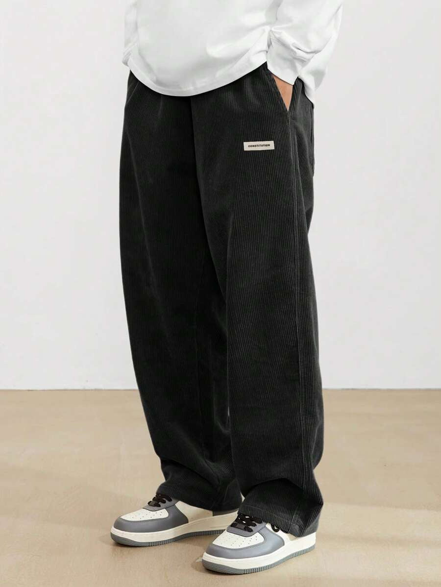 Person wearing black wide-leg pants and a white shirt against a plain background