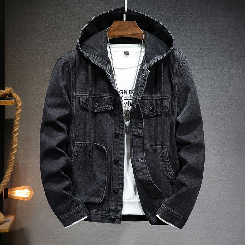 Black denim jacket on a hanger against a gray background