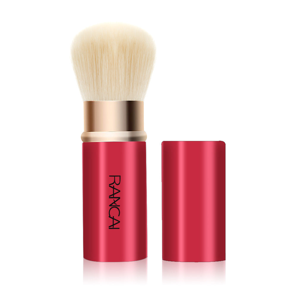 Makeup brush with red handle and gold accents on a white background