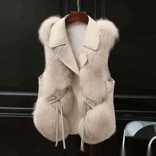 Beige fur vest with a hood on a hanger against a black background