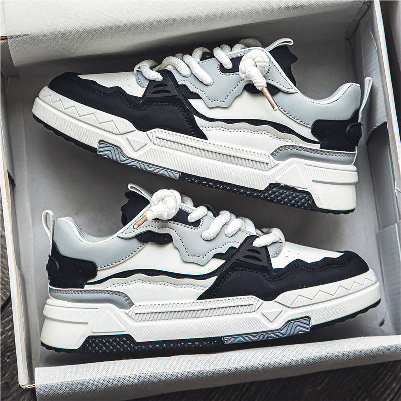 A pair of beige sports board shoes placed inside a shoebox, with the laces tied and the sole visible.