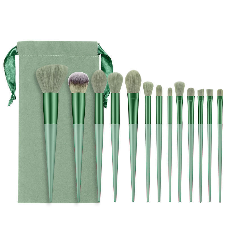 Set of makeup brushes with green handles and silver ferrules on a white background