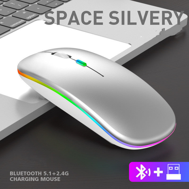 Silver wireless mouse with colorful LED lights on a dark surface, next to a keyboard.