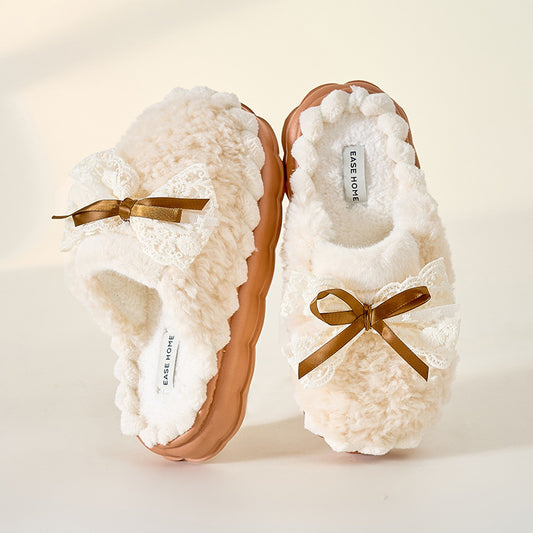 A pair of beige cotton slippers with a bow on the top, designed for women for autumn and winter use.