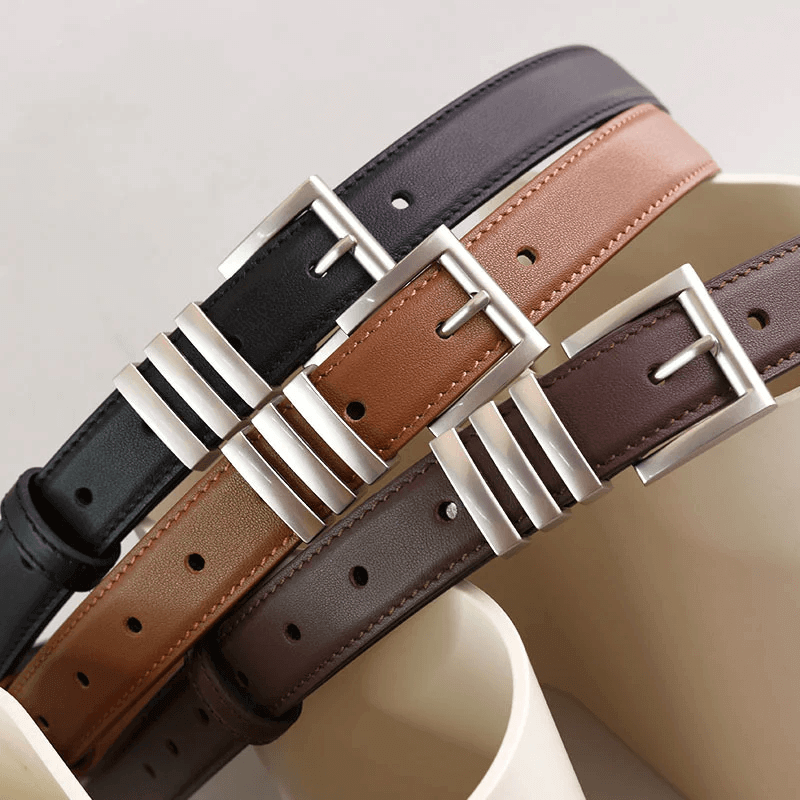 A display of wide leather belts, thin chain belts, and decorative buckles from the Women's Stylish Belts collection