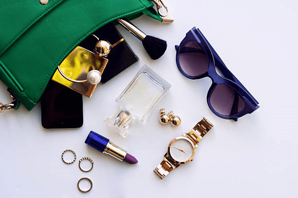 Accessories W. stylish green handbag, sunglasses, watch, jewelry, and lipstick for women.