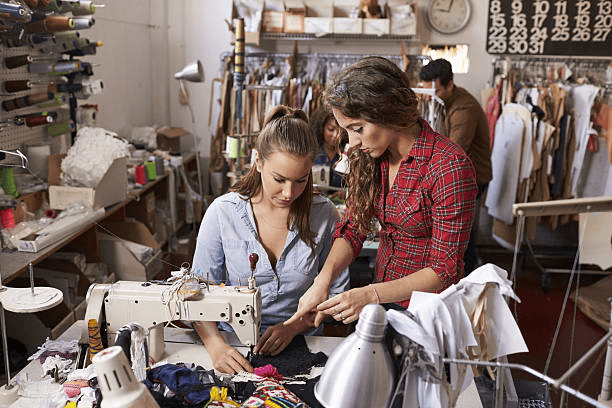 Two women working together on a sewing project in a studio, part of the Arts , Crafts & Sewinng Collection.