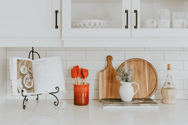 A display of professional cutlery, stainless steel cookware, and measuring cups from the Essential Kitchen Tools collection