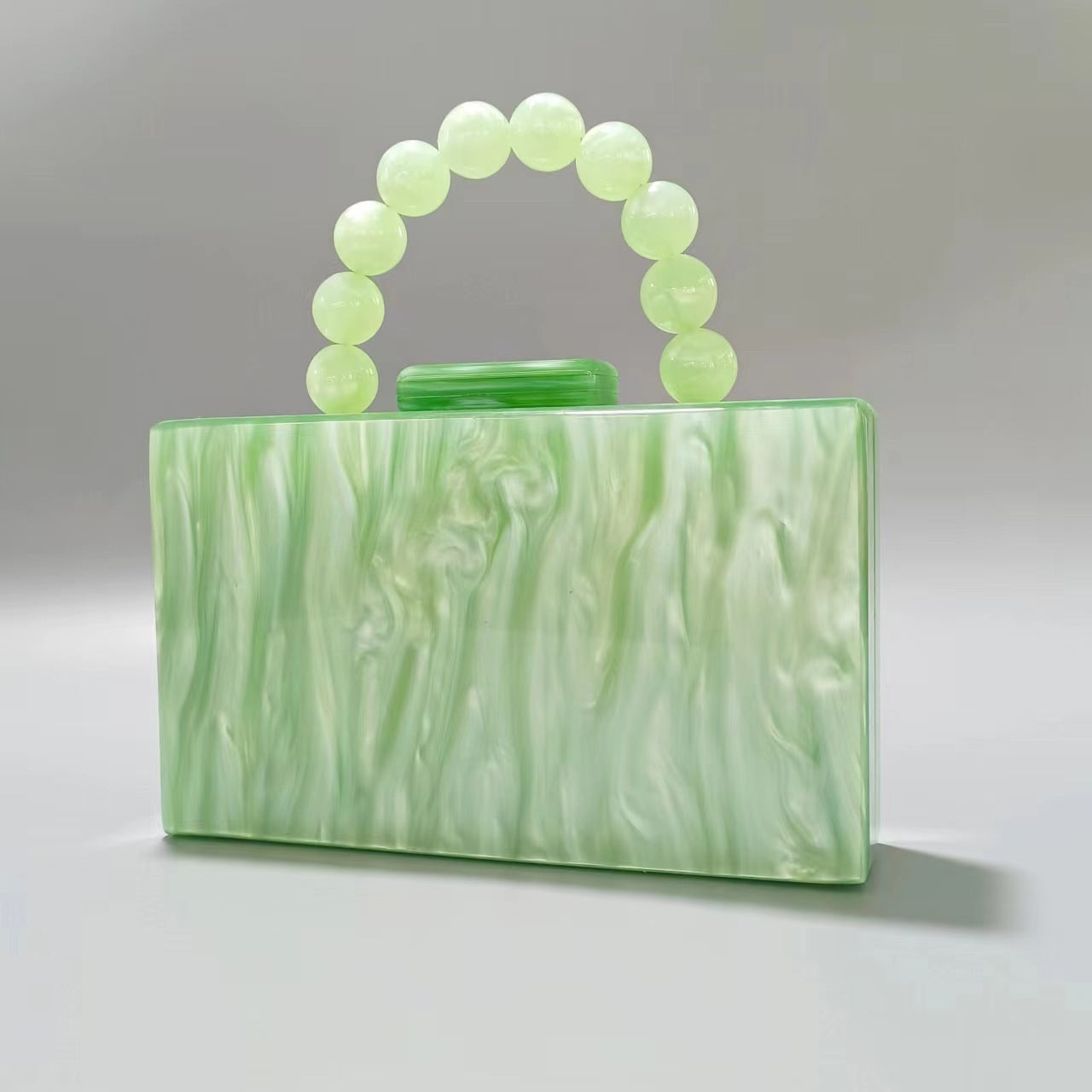 Light green acrylic evening bag with round beaded handle and top clasp