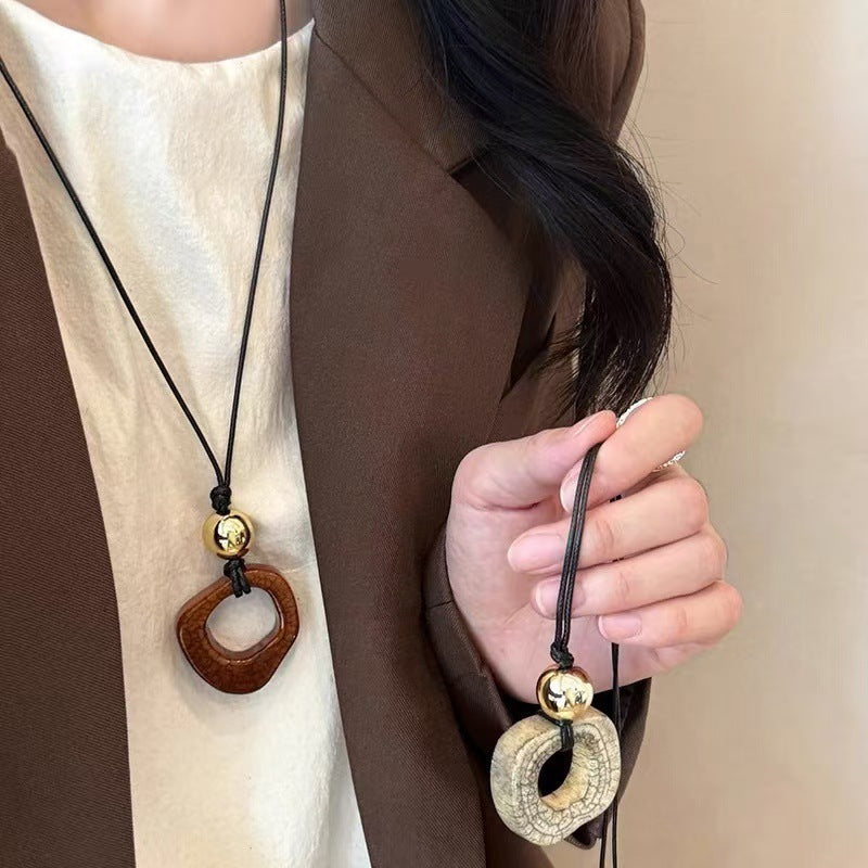 Butterfly pendant necklace with black cord, gold bead, wood and stone drop