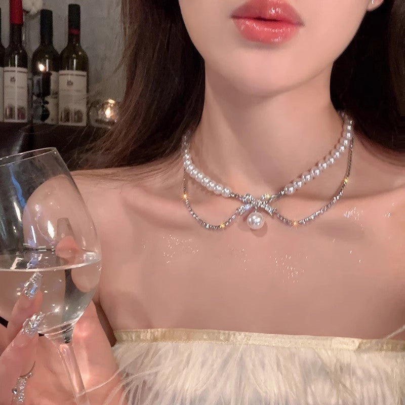 Silver-tone pearl necklace with layered chain and round pearl centerpiece